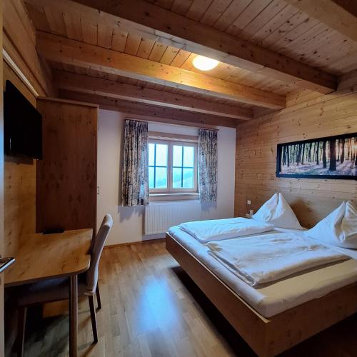 a bedroom with a bed and a table and a desk at Ferienhaus Hochfelner in Sankt Marein bei Knittelfeld