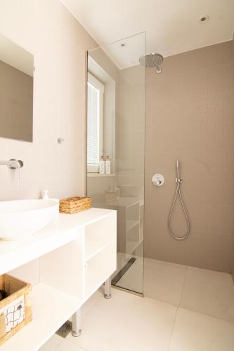 a white bathroom with a shower and a sink at serene villas in Ierapetra