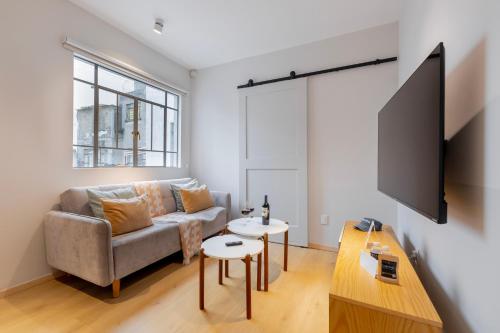 a living room with a couch and a flat screen tv at Capitalia Nuevo Polanco in Mexico City
