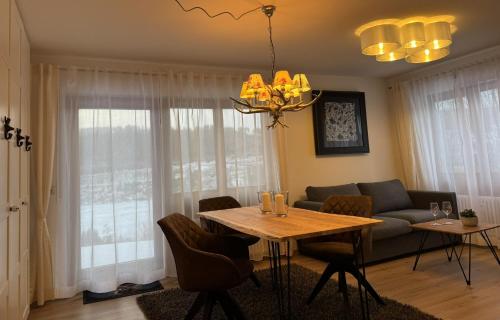 a living room with a table and a couch at Ferienwohnung Waldrose am Titisee in Titisee