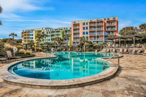 a swimming pool with a hotel in the background at Oceanfront condo with direct beach access, pool, balcony, grilling area, & AC in Fernandina Beach