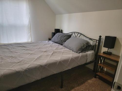 a bedroom with a bed and a lamp on a night stand at Close to everything in Tacoma! in Tacoma