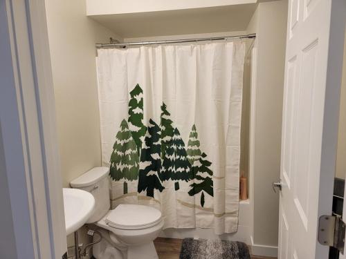 a bathroom with a shower curtain with trees on it at Close to everything in Tacoma! in Tacoma
