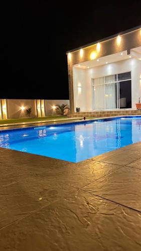 a large swimming pool at night with a house at شالية مزايا الاشخرة in Al Sharqiyah