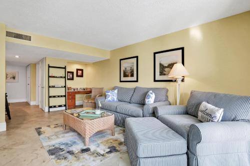 a living room with a couch and a table at Oceanfront condo with direct beach access, pool, balcony, grilling area, & AC in Fernandina Beach