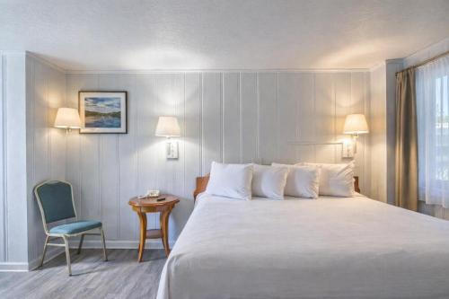 a hotel room with a large bed and a chair at Colony Inn By OYO Columbus US-280 in Columbus