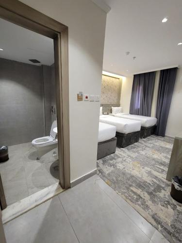 a hotel room with two beds and a bathroom at فندق نخبة الجوار in Al Khansāk