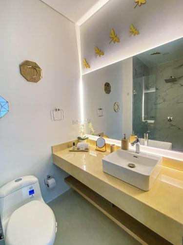 a bathroom with a sink and a toilet and a mirror at Vela Mare Suite in Santa Marta