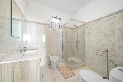 a bathroom with a shower and a toilet and a sink at Caniço Seaview House in Caniço