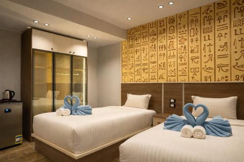 two beds with blue bows on them in a room at Pyraking Pyramids View Hotel in Giza