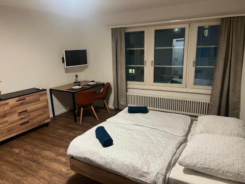 a bedroom with a bed and a desk with a computer at Central Living Brugg - Studio 12 in Brugg