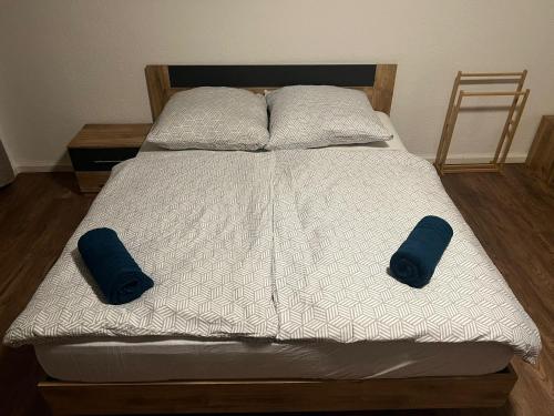 a bed with two blue pillows on top of it at Central Living Brugg - Studio 12 in Brugg