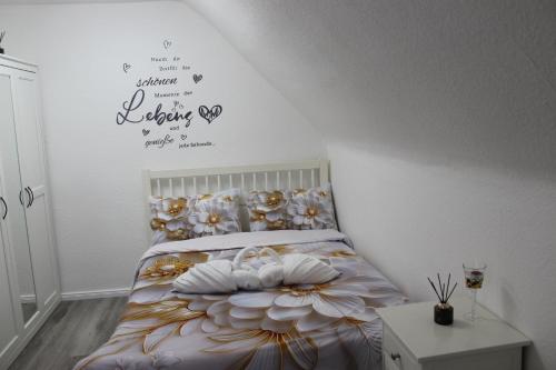 a bedroom with a bed with a flower and a wall at Gemütliche Wohnung in Mendig in Mendig