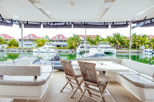 a dining room with a table and chairs and a boat at Akula Catamaran - N4 Charters Seychelles in Victoria