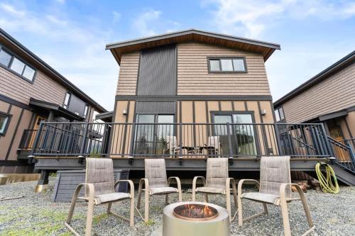 a house with a balcony with chairs and a fire pit at Wild Beauty - Oceanview - Pet Friendly - sleep 2 in Port Renfrew