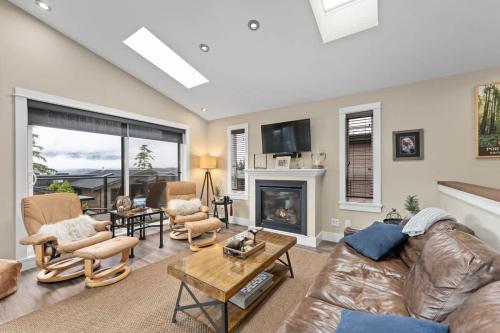 a living room with a leather couch and a fireplace at Wild Beauty - Oceanview - Pet Friendly - sleep 2 in Port Renfrew