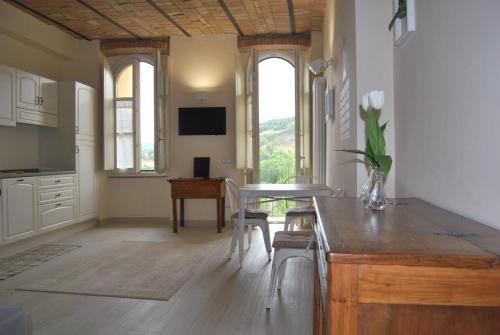 cocina y comedor con mesa y sillas en Suites Bobbio en Bobbio