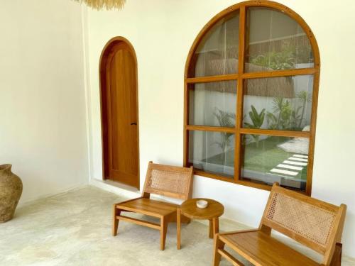 a room with two chairs and a window at Sola Rooms in Kuta Lombok