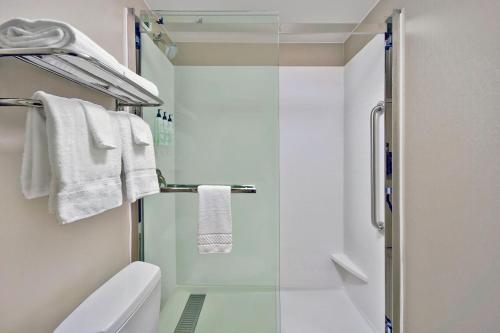 a bathroom with a shower and a toilet and towels at SpringHill Suites By Marriott Erie in Erie