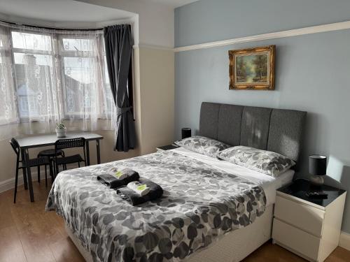 a bedroom with a bed and a table and a table at North West Lodge Guest House in London