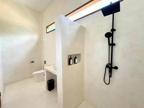a bathroom with a shower with a toilet and a sink at Sola Rooms in Kuta Lombok