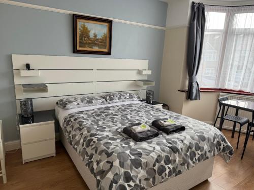 a bedroom with a bed with a black and white comforter at North West Lodge Guest House in London