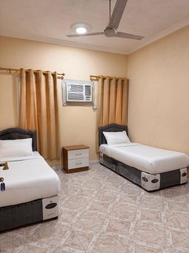 a room with two beds and a window at أجاويد 1 Ajaweed in Salalah