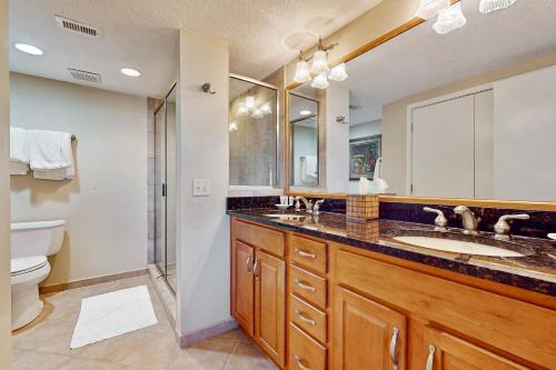 a bathroom with two sinks and a toilet at Oceanfront condo with panoramic views, shared pool, and private washer & dryer in Fernandina Beach