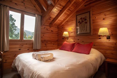 a bedroom with a bed in a log cabin at Apart del Faldeo in San Martín de los Andes