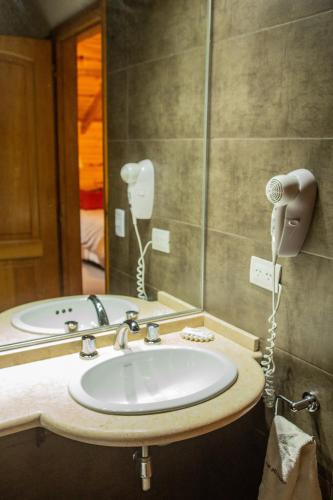 a bathroom with a sink and a blow dryer at Apart del Faldeo in San Martín de los Andes