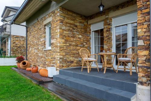 a patio with chairs and a table on a house at Los cuetos, casa para 6 personas con jardín y parking, a pocos minutos de Suances in Suances