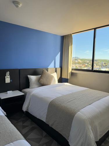 Tempat tidur dalam kamar di Hotel Corona Plaza