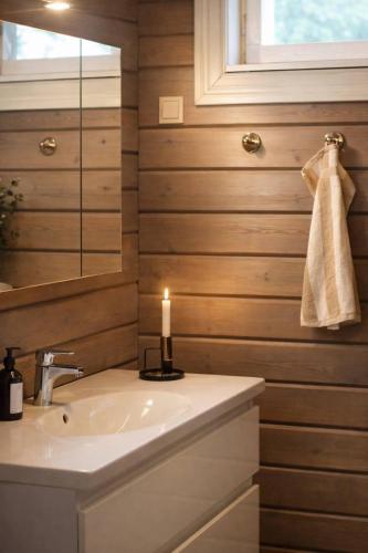 a bathroom with a sink and a candle at Private archipelago villa with large property in Pargas