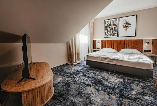 a bedroom with a bed and a table with a television at Hotel Zodiak in Sucha