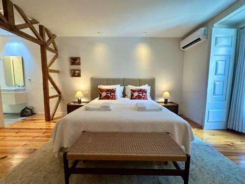 a bedroom with a large bed with a bench in it at My Lisbon Apartment with AC in Lisbon