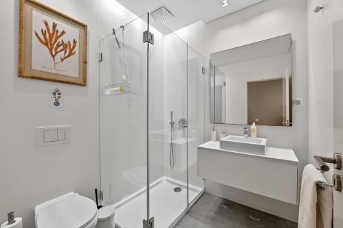 a bathroom with a glass shower and a sink at My Lisbon Apartment with AC in Lisbon