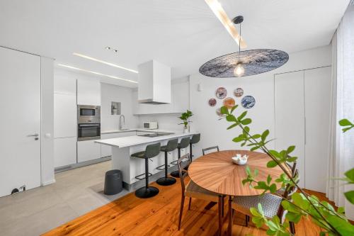 a kitchen with white cabinets and a wooden table at My Lisbon Apartment with AC in Lisbon