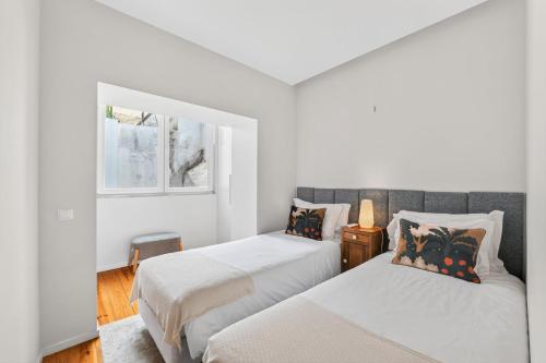 a bedroom with two beds and a window at My Lisbon Apartment with AC in Lisbon