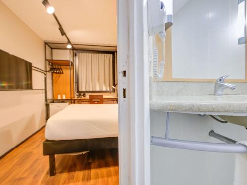 a bathroom with a bed and a sink in a room at ibis Copacabana Posto 2 in Rio de Janeiro