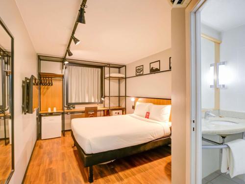 a bedroom with a bed and a bathroom with a sink at ibis Copacabana Posto 2 in Rio de Janeiro