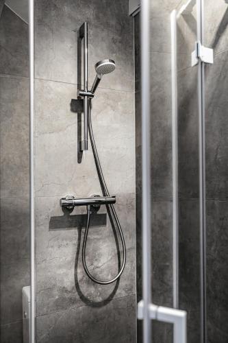 a shower with a shower head in a bathroom at Hotel Zodiak in Sucha