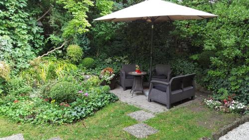 a patio with two chairs and an umbrella at Hotel Romantik Eger in Eger