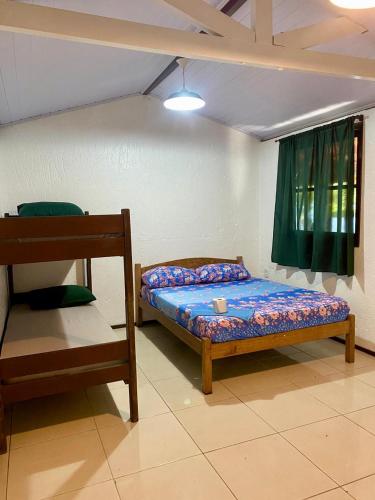 a small bedroom with a bed and a window at Hospedaria aconchego master in Garopaba