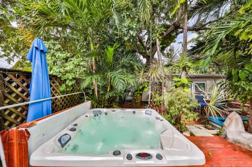 a bath tub sitting on a patio with an umbrella at Garden botanical Villa with jacuzzi in Hollywood