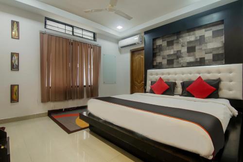 a bedroom with a large bed with red pillows at Hotel OThe Blu Bell in Guwahati