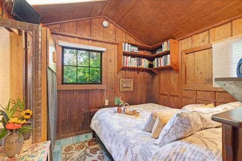 a bedroom with a bed in a room with wooden walls at Volcano Artist Cottage in Volcano