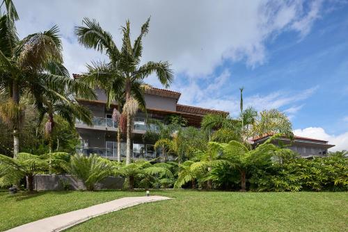 a building with palm trees in front of a park at Tau House in Guatapé