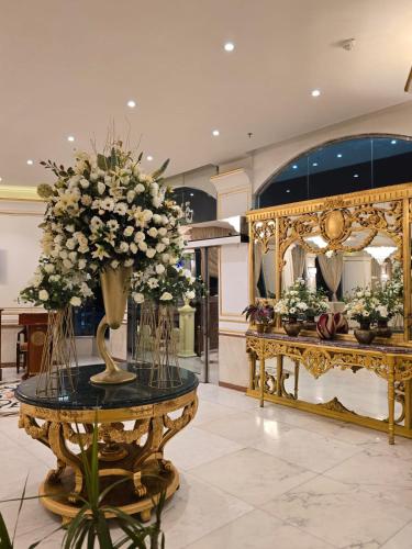 a lobby with a table with a vase of flowers on it at Taj Celine Hotel in Jeddah