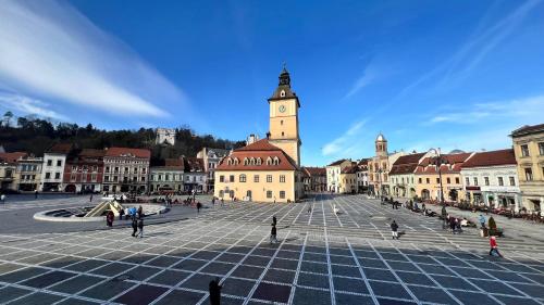 a city square with a clock tower in the background at Residence Piata Sfatului in Braşov
