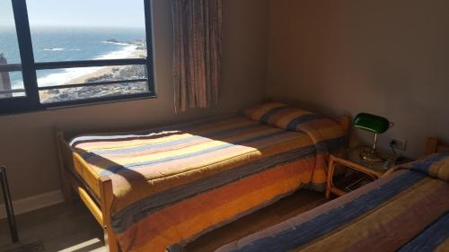 two beds in a room with a view of the ocean at Fortezuelo - Ventisquero Hudson in Viña del Mar
